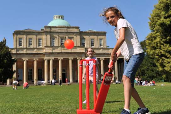 Children playing cricket outside Pittville Pump Room in Cheltenham