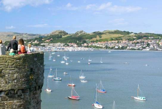 People looking out over the water from Conwy castle