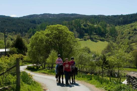 People horse riding in the countryside in Gwydyr Forest