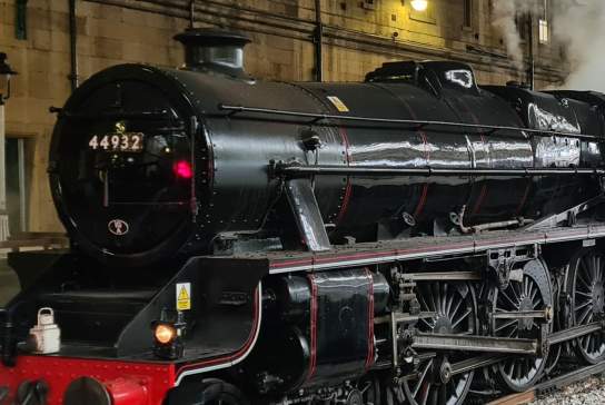 Historic black steam locomotive 44932 releasing steam at a station platform during the filming of Blitz
