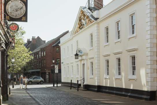 Cobbled street in Hull’s Old Town showing the white façade of Hull Trinity House and surrounding historic buildings