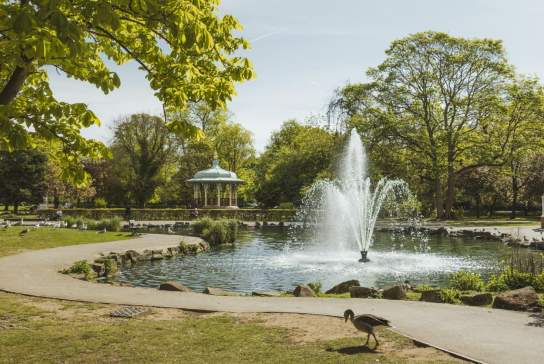 PEarson Park  in Hull with large fountain, lake, bandstand, trees, footpath and greenhouse.