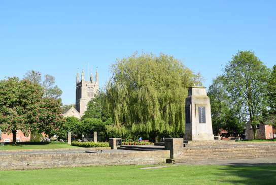 A landscape of Bourne Church and memorial with clear skies