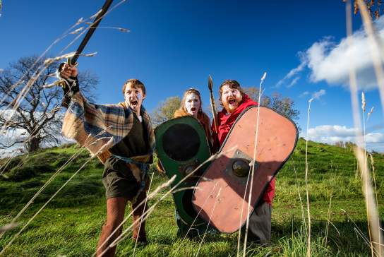 Group of three dressed up in medieval warrior costume at Navan Fort
