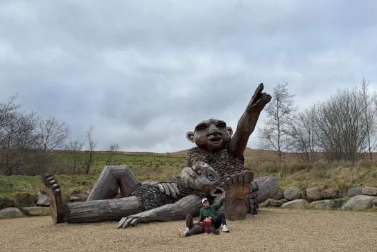 Influencer CatherineLauraM lying down in front of one of the Giants of the Sperrins.