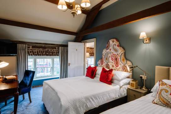 Image of a bedroom at Ralph's showing 2 beds and mood lighting.