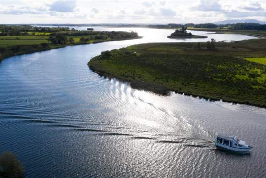 Aerial shot of a boat as part of River Bann cruises on a sunny day.