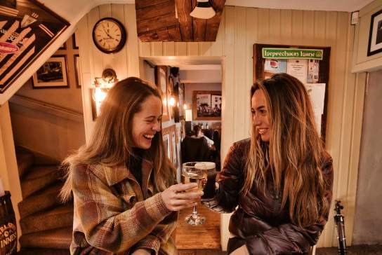 2 girls enjoying a drink in Mary McBride's in Cushendun
