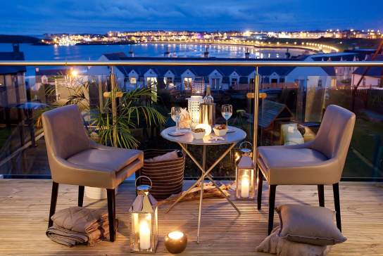 beautiful night time view from the Blackrock House B&B. Candle lit table and two chairs for an evening drink