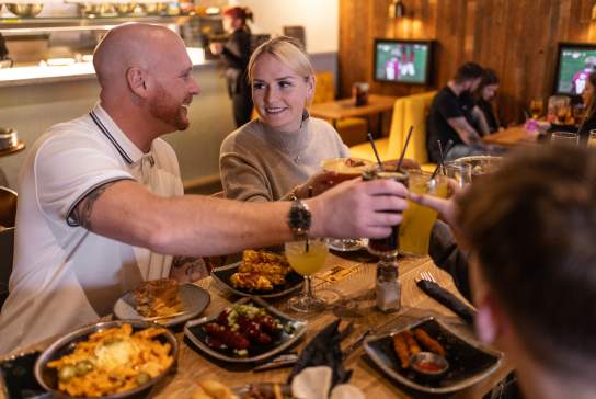 Group of diners enjoying food and drink at Kwackers