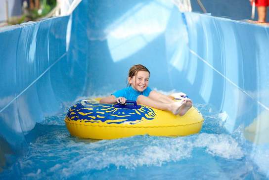 Girl in an inflatable ring on a water slide.