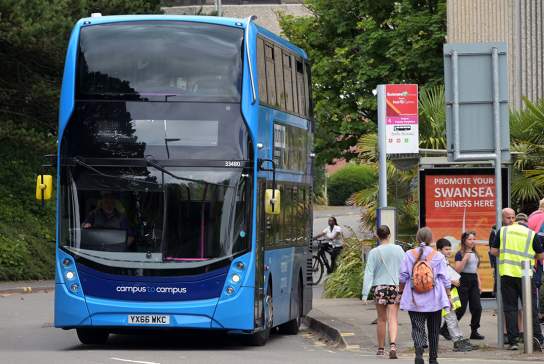 A bus pulling away from a bus stop in Swansea Bay