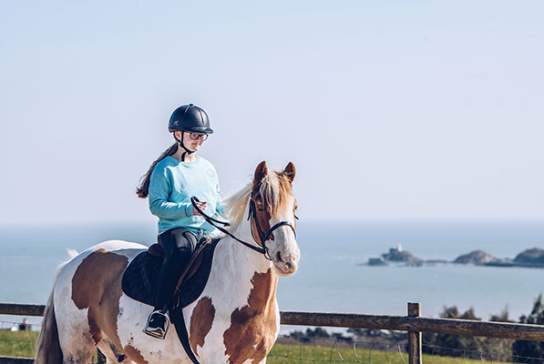 A young girl riding a horse in Swansea Bay
