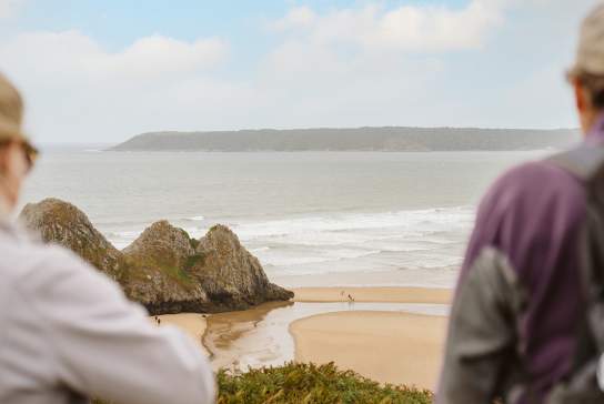 Walkers overlooking Three Cliffs Bay