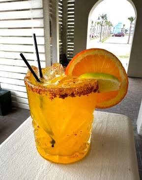 Mango Margarita with an orange and lime wedge on the rim