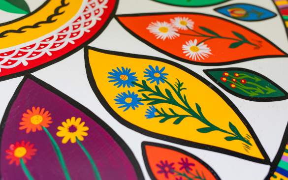 a close up shot of a hex sign painted with bright florals.