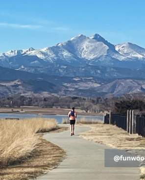 Woman running with Long's Peak in the background