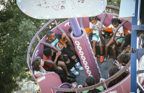 Kids riding one of the spinning rides at the Fun in the Park event for Juneteenth