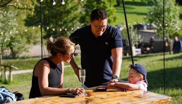 Mum, dad and child sat at table outside