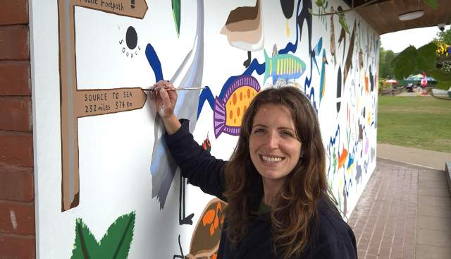 Artist in front of Mural to celebrate Thames Path 30th anniversary at Mill Meadows Pavilion, Henley on Thames