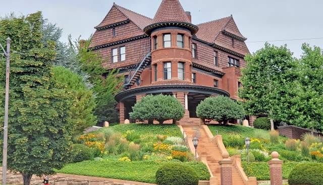 Exterior view of McCune Mansion with green trees