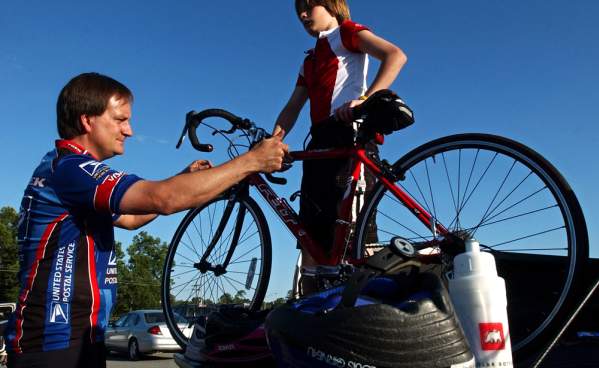 Father and son unloading a bicycle from the back of a pickup truck for biking in Beaumont