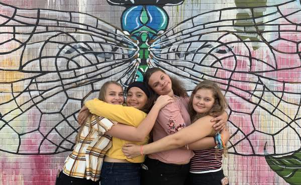 Teens posing in front of Dragonfly wall mural in Beaumont