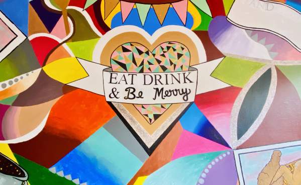 The colorful mural at Stir It Up advises patron to "Eat, Drink, & Be Merry."