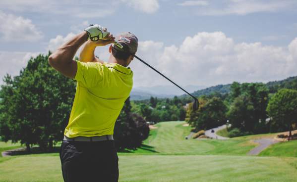 Man taking a golf swing at a golf course in Beaumont, TX