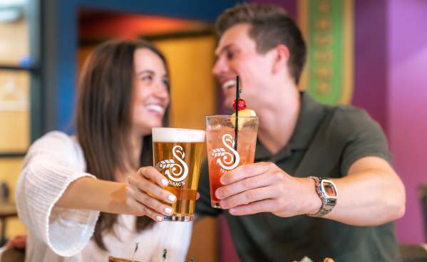 Couple doing cheers with beer at Isaac's Craft Kitchen & Brewery in Lemoyne