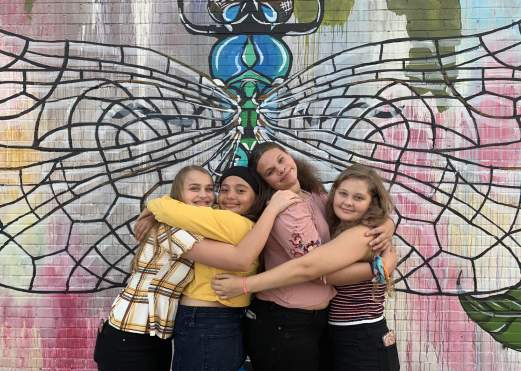 Teens posing in front of Dragonfly wall mural in Beaumont