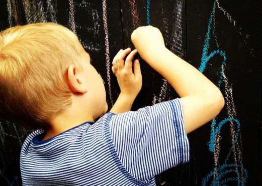 Kid Drawing On The Crown Pizza Chalk Wall In Beaumont, TX