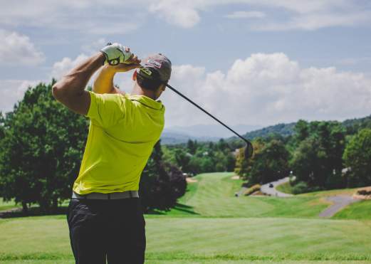 Man taking a golf swing at a golf course in Beaumont, TX