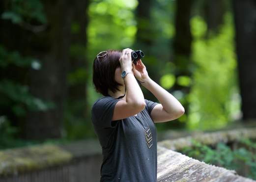 Woman looking through binoculars for birds in Beaumont