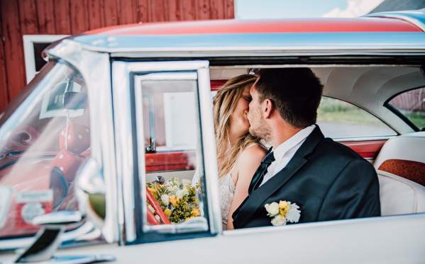 Barn wedding with couple in car