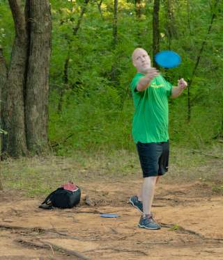 man throwing disc on disc golf course