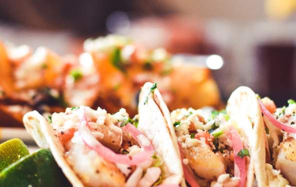 plates of fish tacos and potato chip nachos