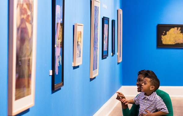 a mom and son look at museum exhibits