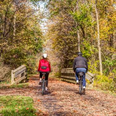 Couple bicycling on the Little Miami Scenic Trail in Fall