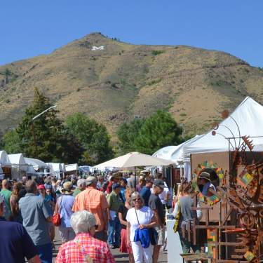 Golden Fine Arts Festival 2018 street crowds and artist booths in downtown Golden Colorado. Mount Zion is in the background.