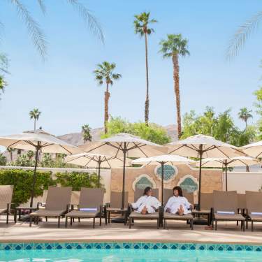 Two woman laying by the pool at Omni Rancho Mirage.