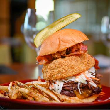 Hamburger with onion ring and pickle from VUE Grille & Bar