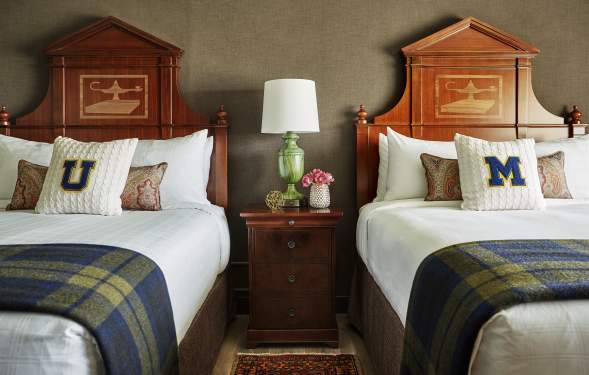 Two beds with U-M pillows at Graduate Ann Arbor