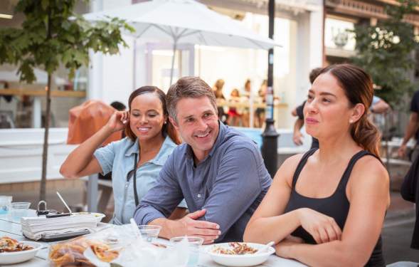Three people dining outside at Fritas Batidos