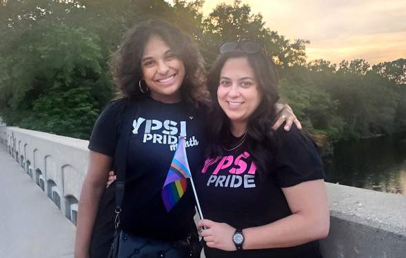 Two women on bridge wearing Ypsi Pride shirts