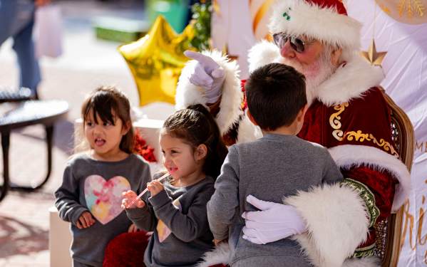 Photo of 3 kids getting to meet Santa during the Christmas Under the Stars festival in Downtown Brownwood