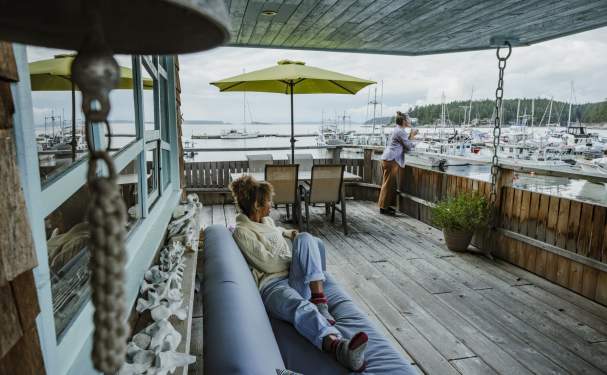 Two women enjoying the marina views from a covered patio.