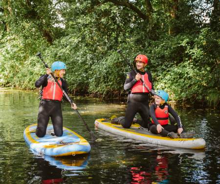 A group of individuals paddle boarding in Swansea