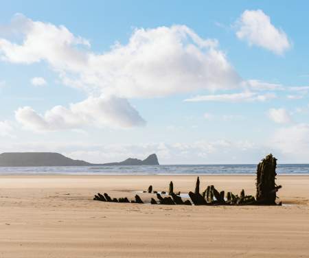 Rhossili beach with the wreck of the Helvetia in the background.