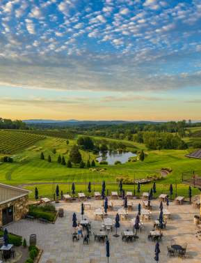Aerial view of Stone Tower Winery's outdoor patio and rolling vineyard at sunset in Leesburg, Virginia.